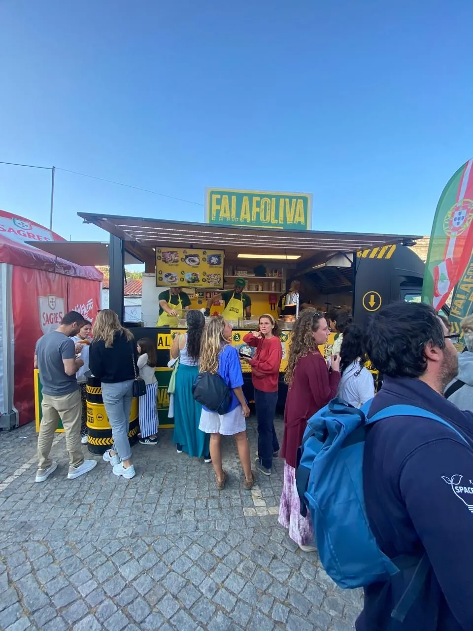 A queue at the Falafoliva truck on a sunny day
