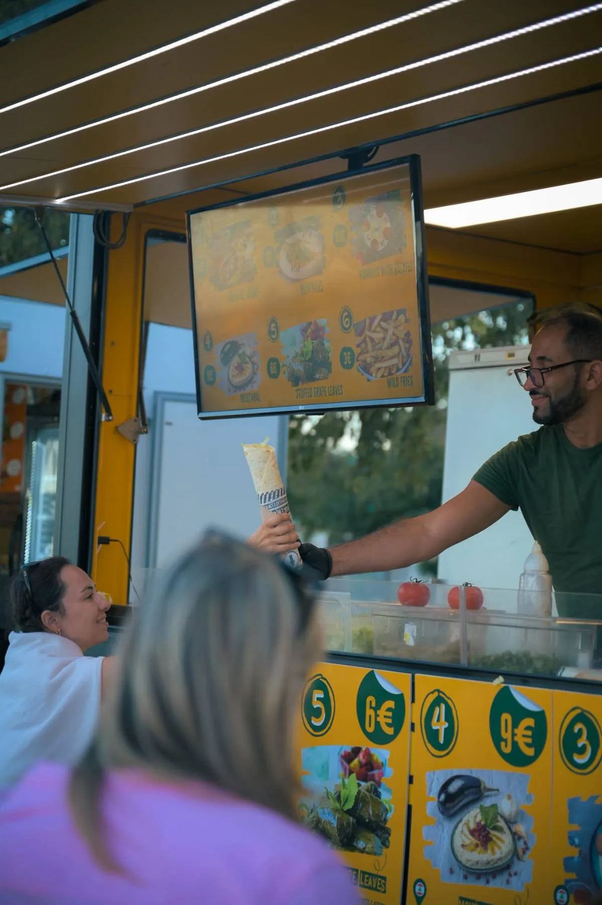 Serving a falafel wrap through the truck window